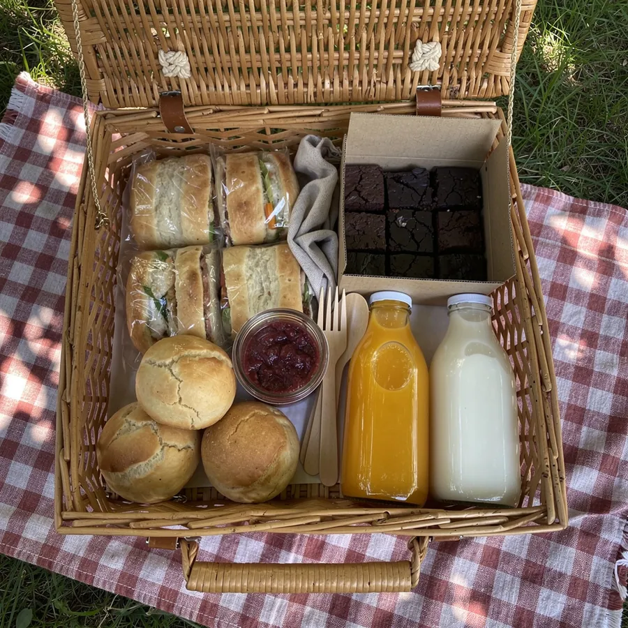 Wicker picnic basket with sandwiches and juice Wicker picnic basket with sandwiches and juice